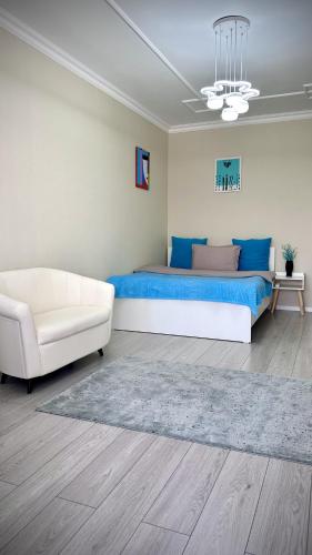 阿拉木图Новая квартира с панорамным видом на горы的一间卧室配有一张床和一张白色沙发