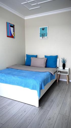 阿拉木图Новая квартира с панорамным видом на горы的一间卧室配有一张带蓝色床单的大床