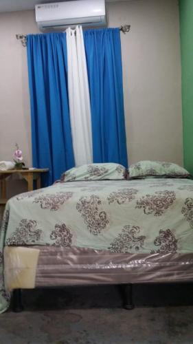 Hotel Infinity的一间卧室配有一张蓝色窗帘的床