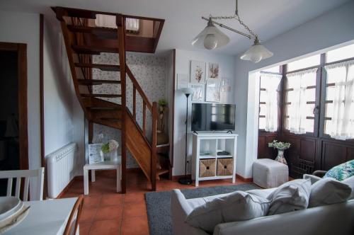 桑提亚纳德玛玛丽亚之家公寓的一间带螺旋楼梯和电视的客厅