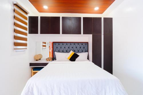 CabanganQ Beach Resort的卧室配有白色的床和木制床头板