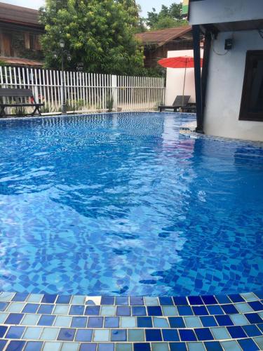 万荣Vang Vieng Sky Mountain View Hotel的游泳池设有蓝色瓷砖地板和白色围栏