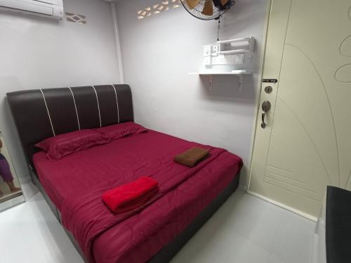 马兰ROOMSTAY NIMAZA Bilik 2的小房间的小床,有红色的床单