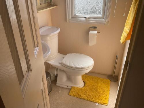 GreatstoneRomney Sands holiday home的一间带白色卫生间的浴室和窗户。