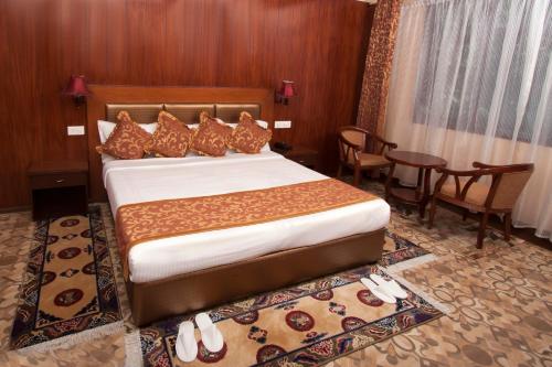 甘托克Yarlam Portico的酒店客房带一张床、一张桌子和椅子