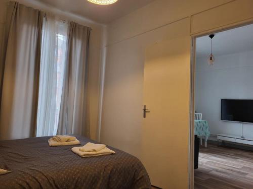 叙雷纳Cosy Appartement Paris Ouest的一间卧室配有一张床,上面有两条毛巾