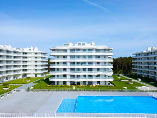 洛格沃Rogowo Pearl City Apartments的享有两座带游泳池的大型建筑的景致