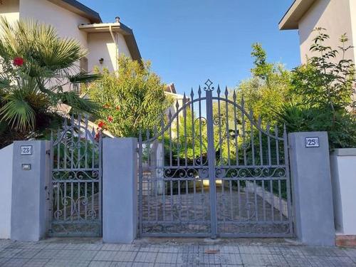 切奇纳Villino Toscana d'Amare con giardino e posto auto privato的楼前有房子的大门