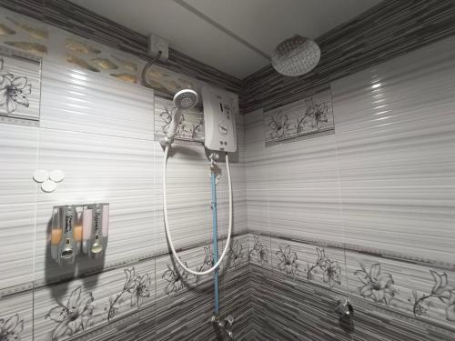 马兰ROOMSTAY NIMAZA Bilik 2的墙上涂鸦的浴室里设有淋浴