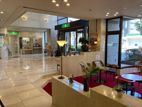 松山Sky Hotel的大楼内带桌椅的大堂