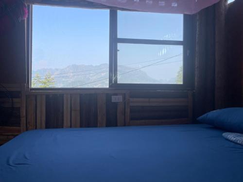 Bảo LạcBao Lac Homestay Hostel & Coffee的一间卧室设有一张床和一个大窗户