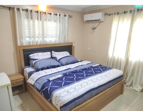 AbeokutaInviting 2-Bed House in Abeokuta的一间卧室配有一张带蓝色床单和枕头的床。