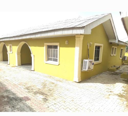 AbeokutaInviting 2-Bed House in Abeokuta的砖车道黄色房子