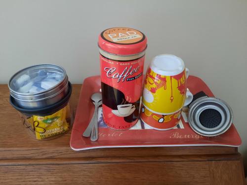 阿尔特罗摩勒床和早餐的盘子上放着两罐可乐和杯子