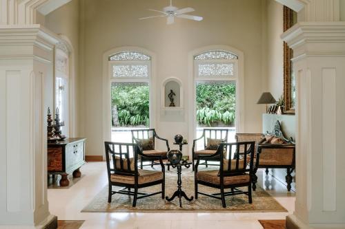 科伦坡玛尼帕西度假酒店的用餐室设有椅子、桌子和窗户