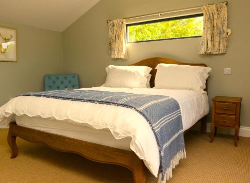 LeighThe Cabin at the Croft - Idyllic rural retreat perfect for couples and dogs的一间卧室设有一张大床和窗户