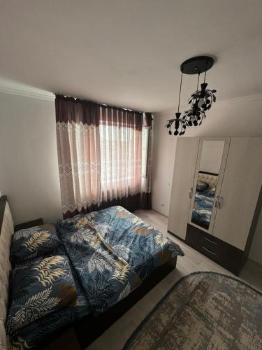 TürkistanComfort Turkestan的一间卧室配有一张床和一个吊灯
