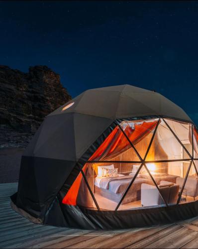 瓦迪拉姆Desert relax camp的夜间在海滩上坐的帐篷