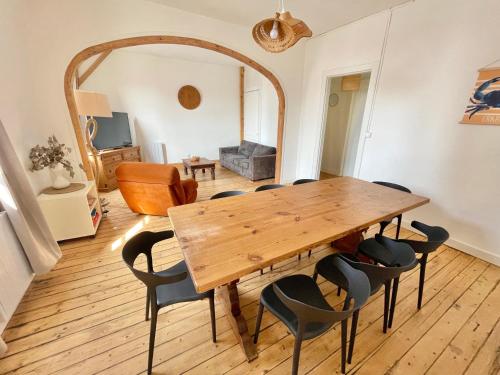 滨海贝尔克Joli T4 au coeur de Berck-Plage的一间带木桌和椅子的用餐室