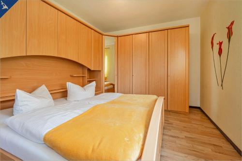 黑灵斯多夫Am Schulberg Ferienhaus Albatros的一间卧室配有一张大床和木制橱柜。