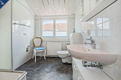 黑灵斯多夫Am Schulberg Ferienhaus Albatros的白色的浴室设有水槽和卫生间。