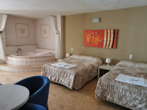 比纳罗斯Hotel Castellverd的酒店客房设有两张床和浴缸。