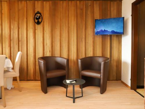 威拉尔-苏-罗伦维拉尔河畔欧伦法加玛特公寓酒店的房间里的两张椅子和一张桌子