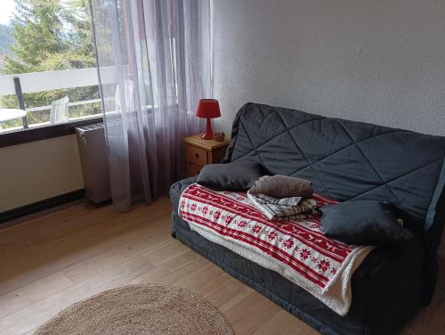 尚鲁斯Chamrousse - Résidence Eterlou的带床、毯子和窗户的客房