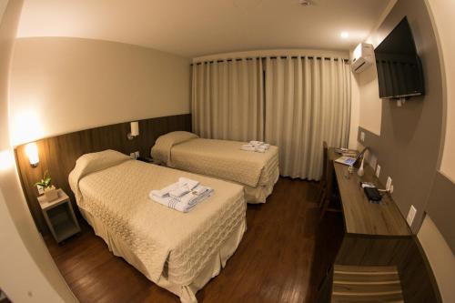 圣玛丽亚Hotel Dom Rafael Premium的酒店客房,配有两张带毛巾的床