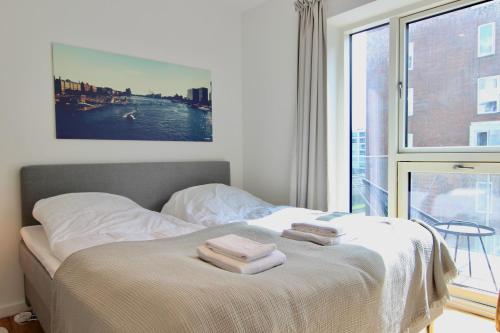 哥本哈根Modern 2-bed wbalcony in Ørestaden的一间卧室配有一张床,上面有两条毛巾