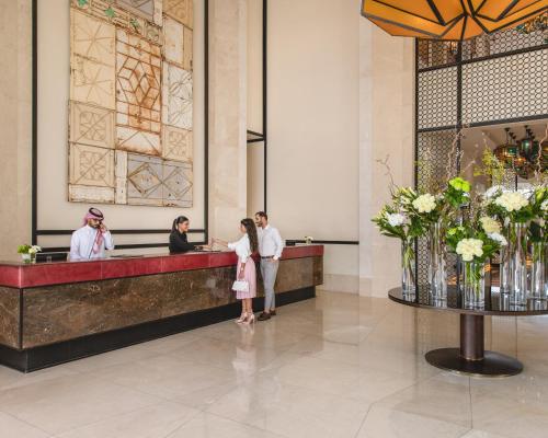 吉达Assila, a Luxury Collection Hotel, Jeddah的一群人站在大堂的柜台上