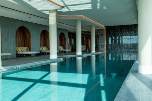 贝斯特Van der Valk Hotel Eindhoven-Best的大楼内带桌椅的游泳池