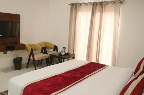 范兰德凡Guru Kripa sadan的一间卧室配有一张床、一张桌子和一台电视