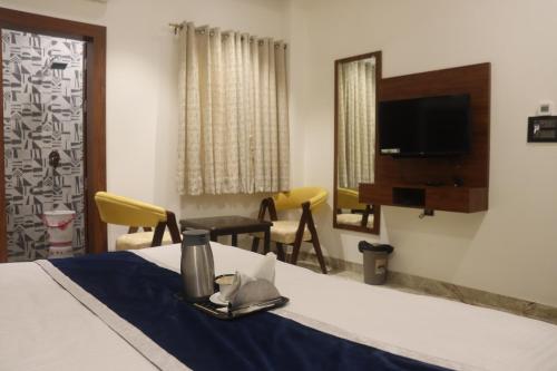 范兰德凡Guru Kripa sadan的客房设有一张带桌子和镜子的床