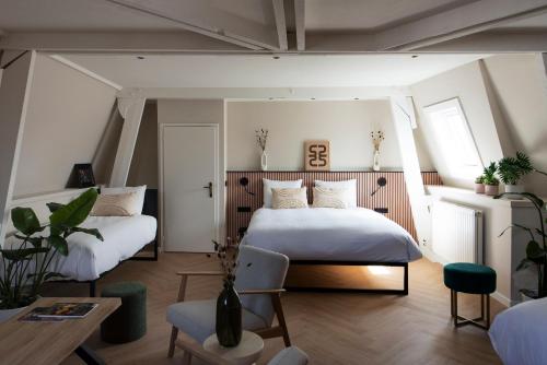 马斯特里赫特波什斯坦什伯格酒店的一间卧室配有两张床和一张桌子