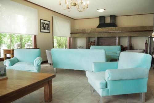 埃尔卡拉法特Sent Calafate的客厅配有蓝色的椅子和桌子