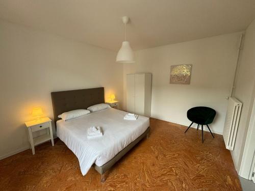 基亚索Smart Living Swiss的卧室配有白色的床和黑椅