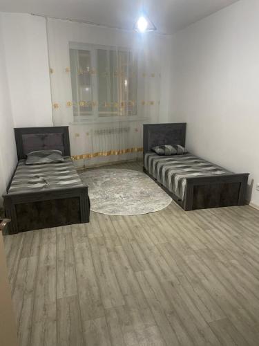 Tridtsatʼ Let KazakhstanaЖана кала, 11-ая улица, 3-х комнатная квартира的铺有木地板的客房内的两张床
