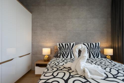 格丁尼亚04 Gdynia Premium - Apartament Mieszkanie dla 2 osób z parkingiem的白色的天鹅坐在床上