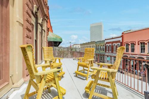 加尔维斯敦Historic Strand Lofts by 3rd Coast Getaways的阳台一排黄色椅子