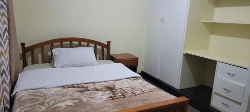 利隆圭Cozy Paradise Apartment的一间小卧室,配有一张床和一个梳妆台