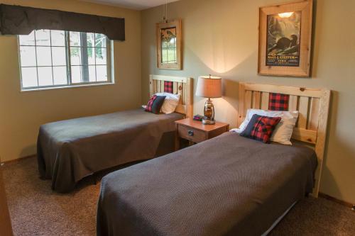 伊格尔里弗野鹰旅馆的一间卧室设有两张床和窗户。