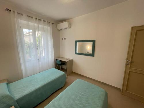 费尔蒂利亚Casa Mari的一间卧室设有两张单人床和一个窗户。