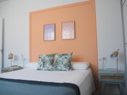 莫切Agua Salá A 200m de la playa zona tranquila的一间卧室配有一张带橙色床头板的床