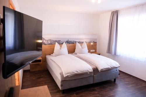 格拉本斯塔特Ferienwohnung beim Binder的一间卧室配有一张床和一台平面电视