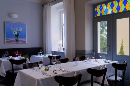 玛丽亚温泉Boutique Hotel SwissHouse的餐厅设有白色的桌椅和窗户。