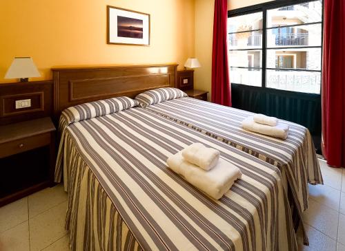 巴耶格兰雷伊三棵棕榈树度假酒店的酒店客房,配有两张带毛巾的床
