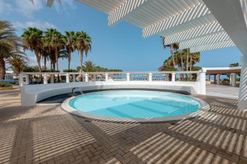 萨尔雷VOI Praia de Chaves Resort的棕榈树庭院内的游泳池