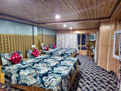 帕哈尔加姆New Snow View Resort pahalgam的一间设有四张床和电视的房间