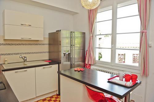阿维尼翁莱斯霍滕西亚公寓酒店的厨房配有白色橱柜和黑色台面